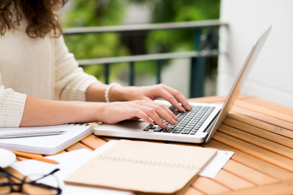 Side view of woman working on laptop, selective focus