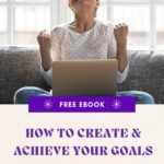 Woman sat crossed legged on a grey couch celebrating success with an open laptop in front of her. Overlaid with the words, "Download your free "How to Create and Achieve Your Goals" eBook".